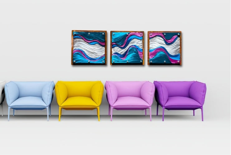 Three candy-painted steel wave panels in teal, pink, and silver hung in a row above a line of colorful lounge chairs.